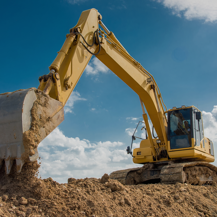 Construction excavator operating on dirt mound.